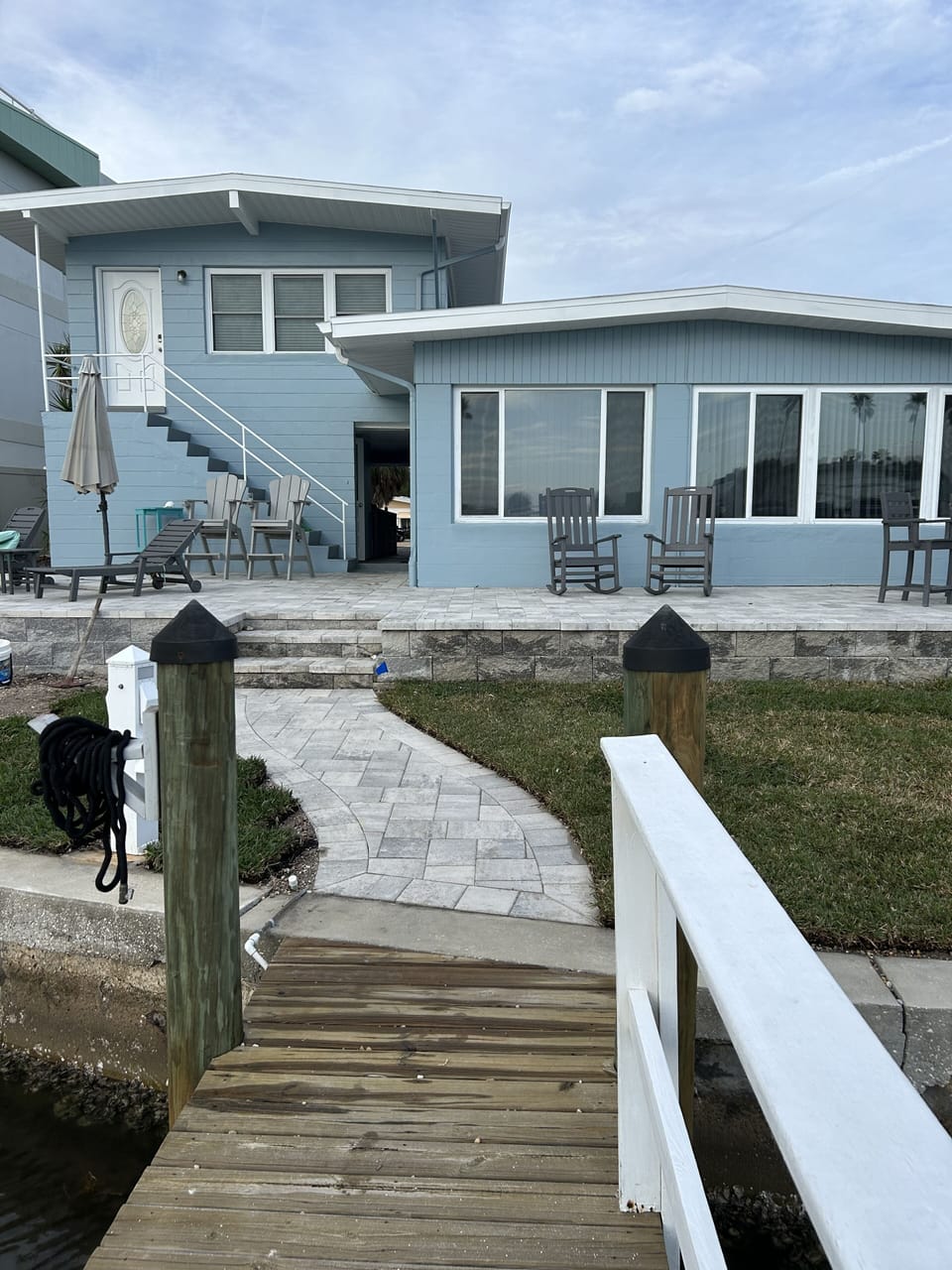 Back of home with sod and large patio with umbrellas to enjoy!