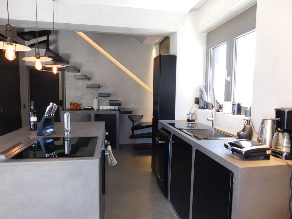 Boutique House kitchen, floating stairs, & doors to downstairs bedroom & shower.