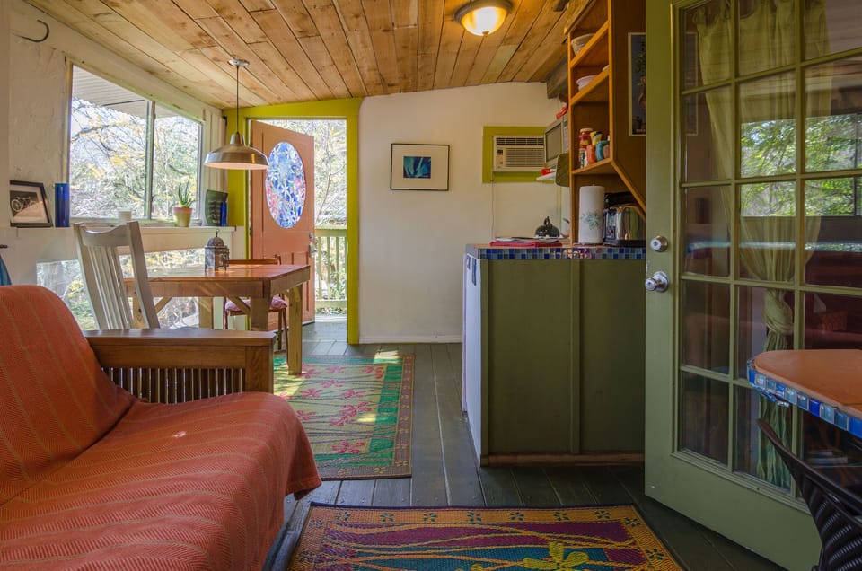 Casita Roja - futon couch (foreground), kitchenette (right), kitchen table