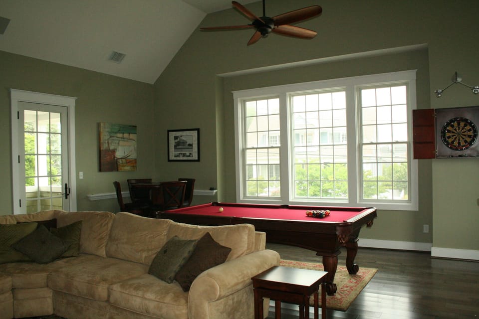 adult/kids playroom with dart board, pool table, and large sectional sofa