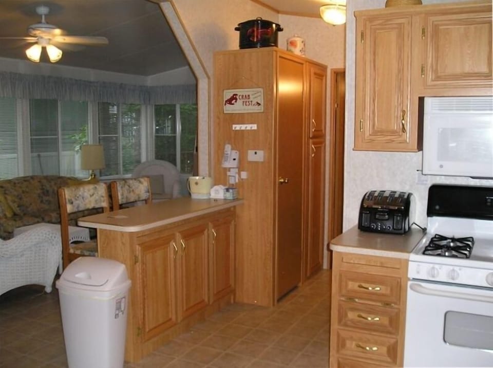 breakfast bar separates kitchen from sunroom; hall w/closets to large bedroom