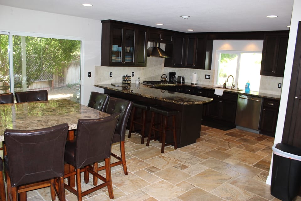 Spacious Brazilian granite counters, 3 leather barstools, 8 leather pub chairs