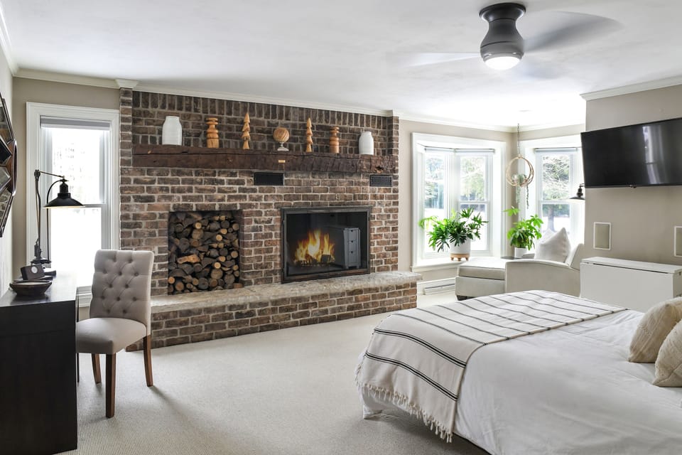 First floor master bedroom with a queen bed, fireplace, TV, and walk-in closet.
