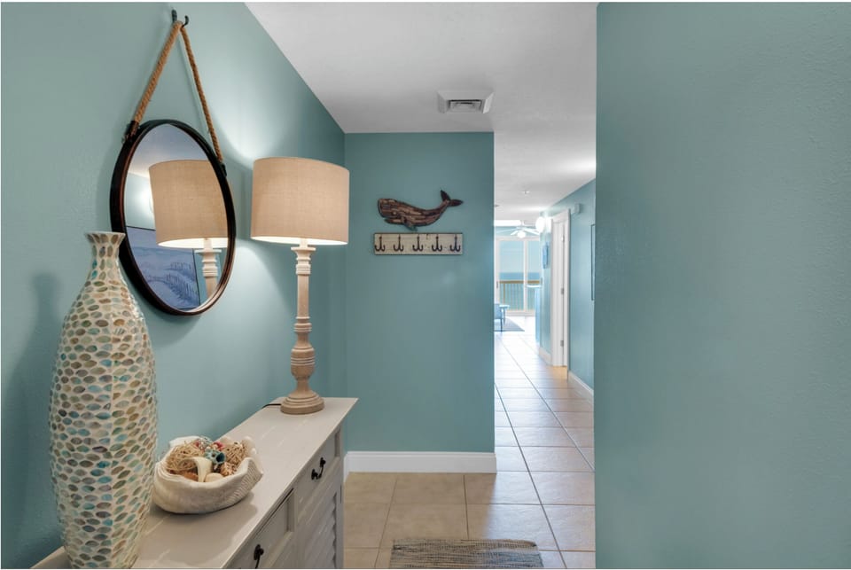 Step into your coastal sanctuary where soothing seafoam walls and nautical touches create the perfect beachside retreat atmosphere.