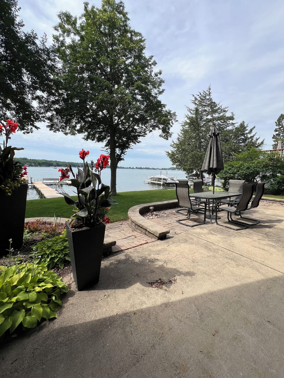 Patio views of the lake featuring patio table & fire pit.