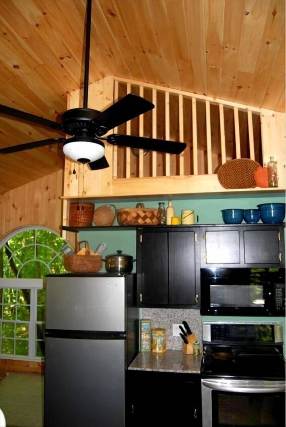 Eco Cabin 1 side of kitchen w/ sleeping loft above it.