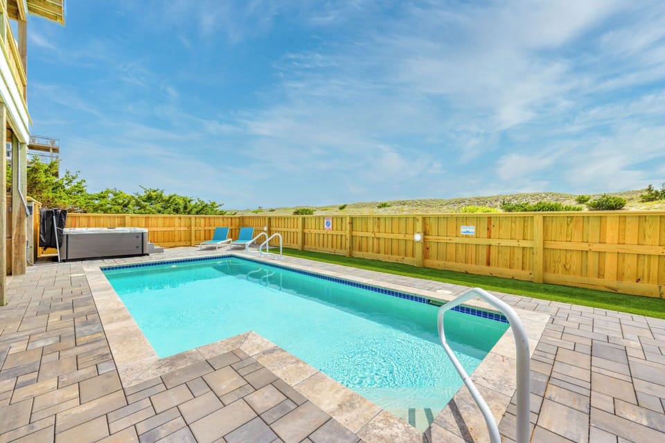 The sparkling blue pool invites you to cool off in privacy beneath the clear blue summer sky.