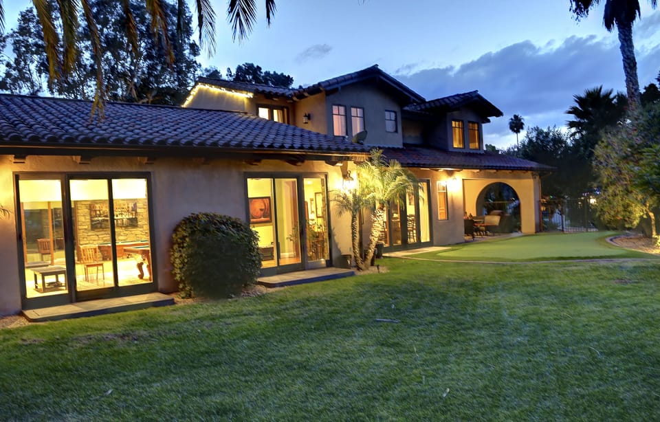Backyard behind guest house with putting green