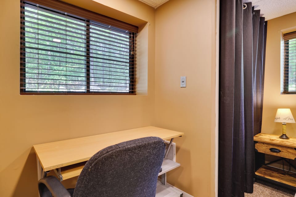 Cozy basement bedroom: queen bed, workspace, nightstands & bright natural light.