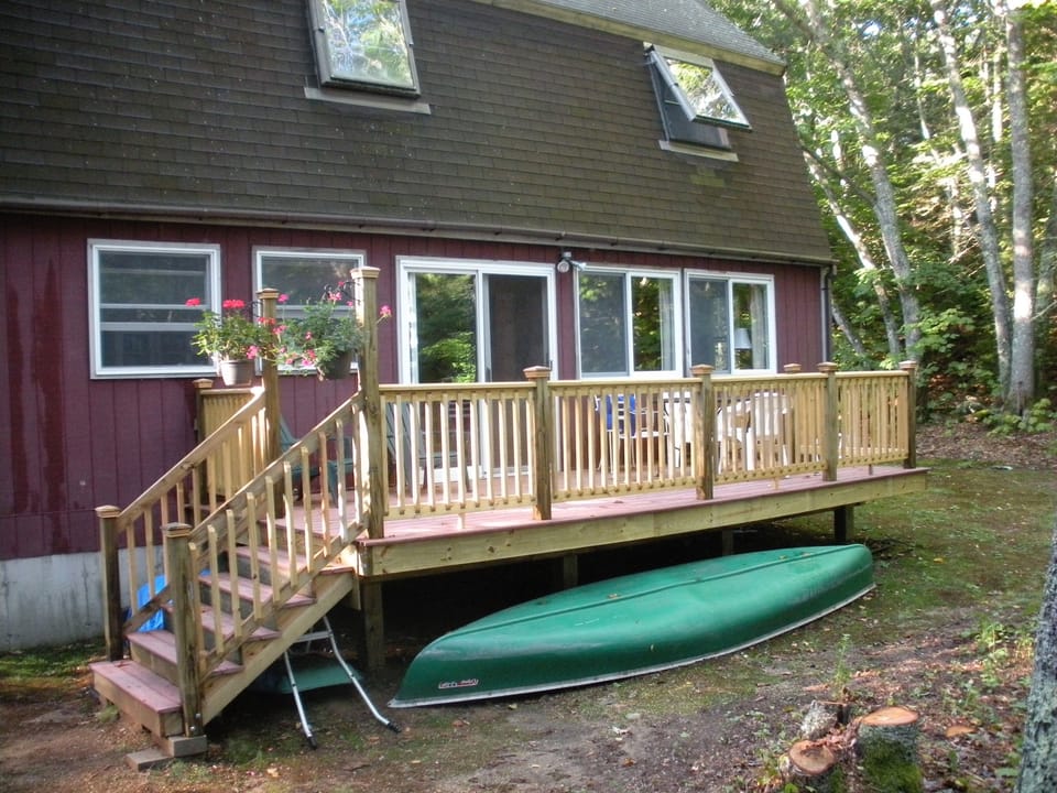 Back view of the cottage with deck and canoe