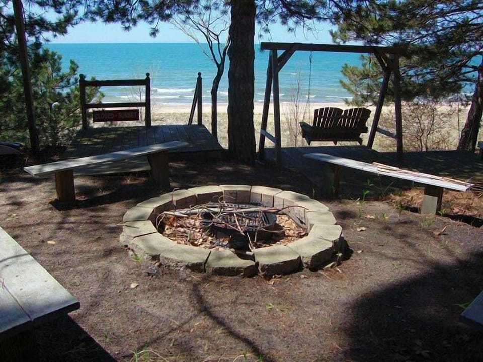 Built in fire-pit with bench seating and double swing overlook the lake.
