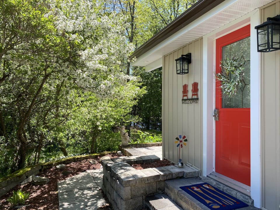 Charming entrance to the cottage and wrap around stone patio.
