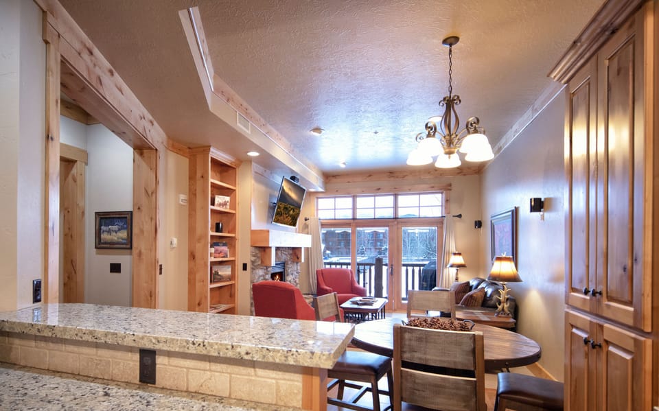 Step into your mountain retreat where rustic charm meets modern comfort. The open layout flows from kitchen to living area, perfect for gathering with loved ones by the fireplace after a day of adventure.