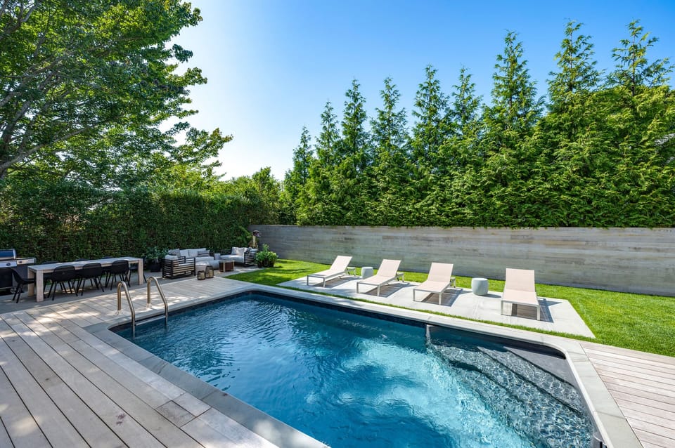 Salt water pool, outdoor shower, dining table, outdoor living room, grill.