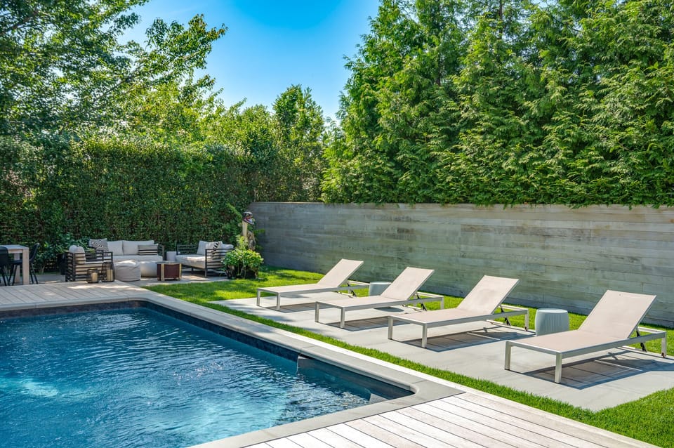 Salt water pool, outdoor shower, dining table, outdoor living room, grill.