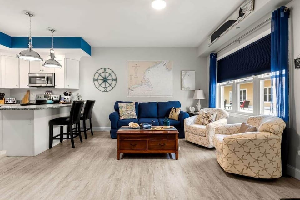 Open living room & kitchen, with mounted smart TV, Dining table, strong WiFi, sleeper sofa and fully-equipped kitchen