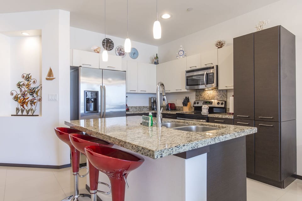Open concept kitchen with all stainless steel appliances and oversized island.