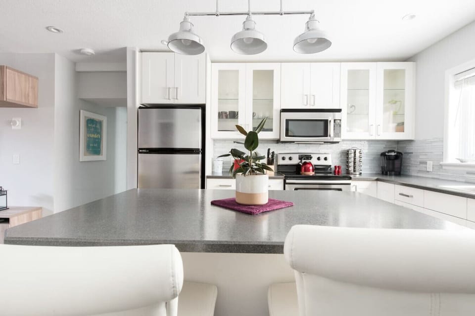 Modern kitchen and dining space with stainless steel appliances and a spacious island—perfect for cooking, gathering, and enjoying a comfortable stay.