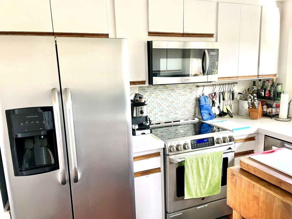 Large side-by-side refrigerator, GE, café, stove and oven, all baking pans too.