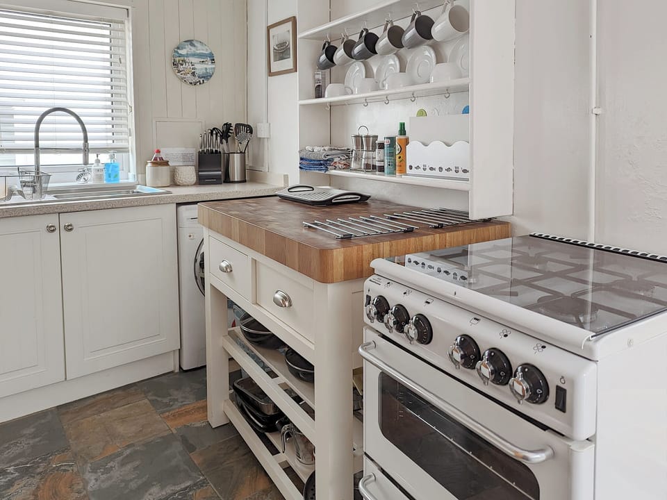 Kitchen with washing machine and gas oven | Trinity Cottage, Wells-next-the-Sea