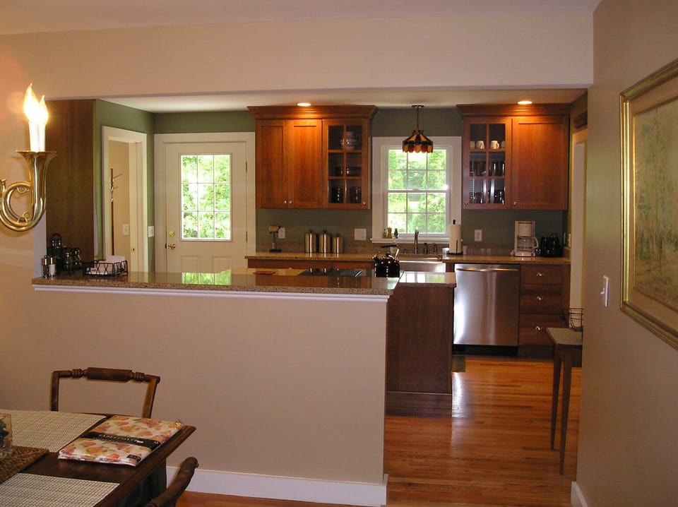 New kitchen opens onto private bluestone patio with outdoor furniture and grill.