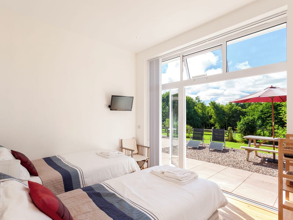 Relaxing twin bedroom with access to terrace | The Red Barn, Braunton, near Barnstaple