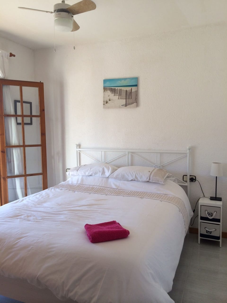 New kingsize bed in master bedroom, with ceiling fans, doors opening to balcony