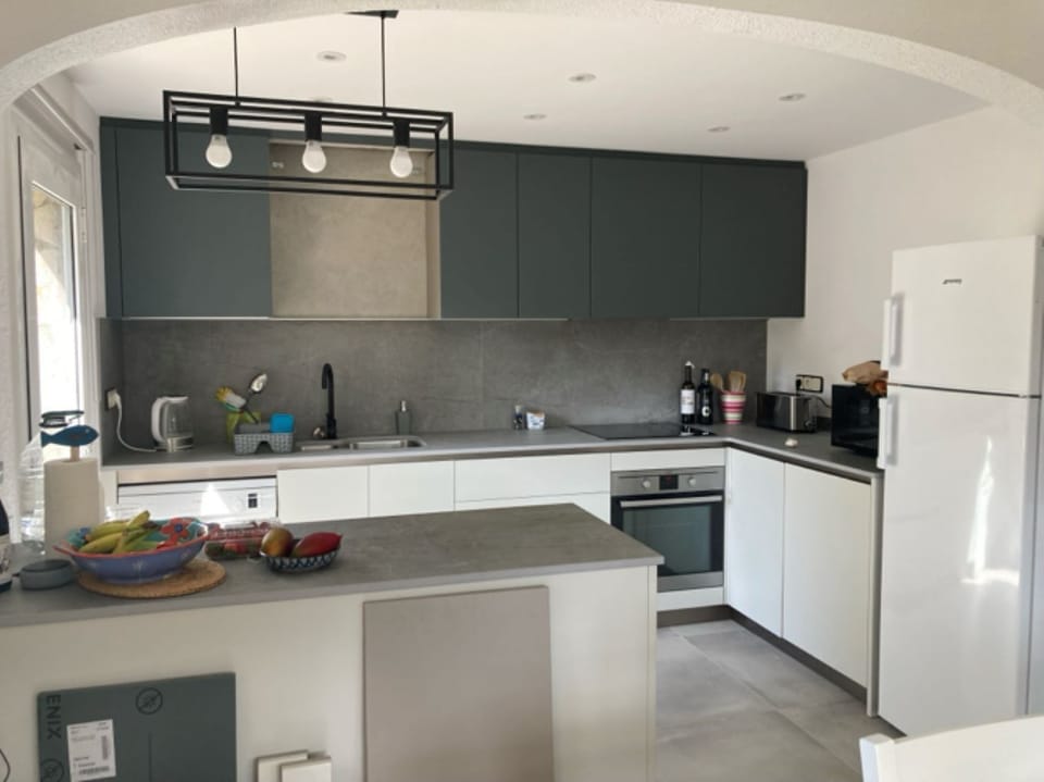 Photo shows kitchen with the back door to side of the house