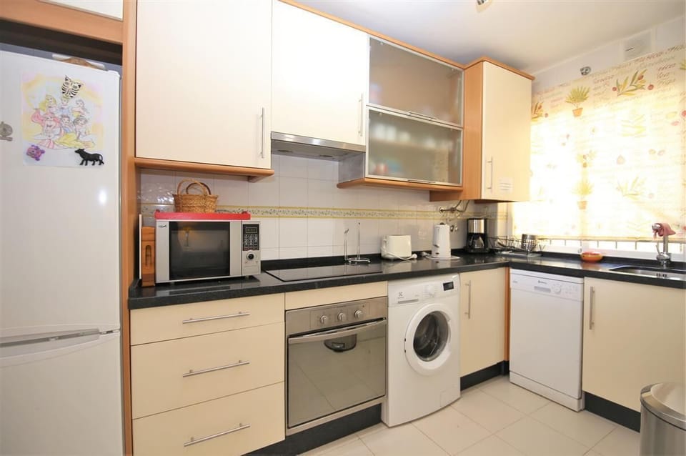 Kitchen in this apartment is fully equipped with all the appliances