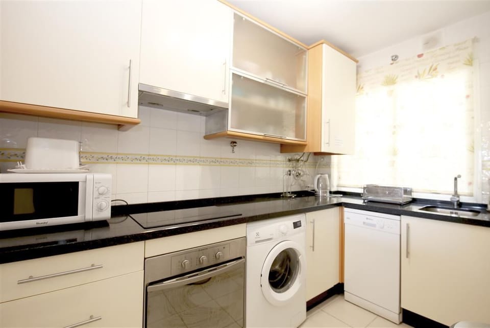 Kitchen in this apartment is fully fitted with all the appliances