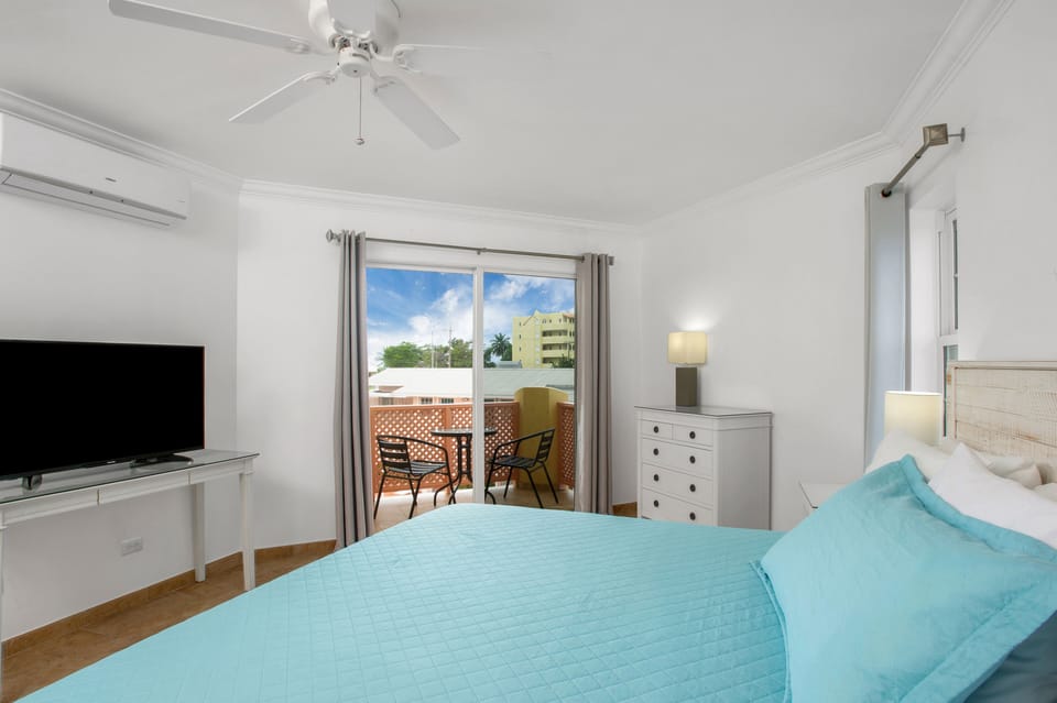 Primary bedroom with King size bed, en-suite bathroom, walk-in closet & balcony.