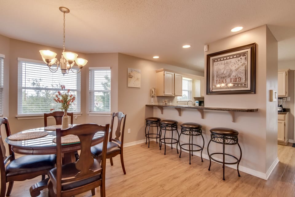 Dining Area - The dining area offers a table with seating for 4, and additional seats at the adjacent bar.