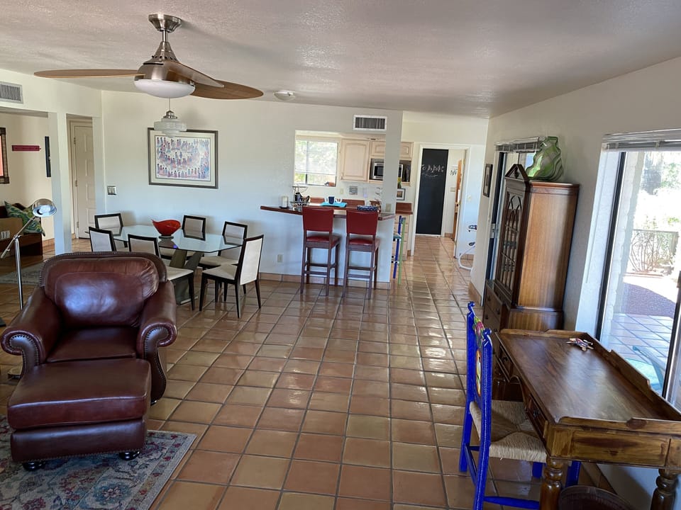 Living room with writing desk looking towards kitchen and garage entrance