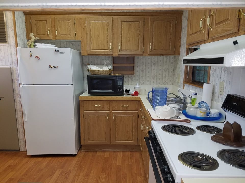 Kitchen w/stove, fridge, microwave and cook/dinnerware