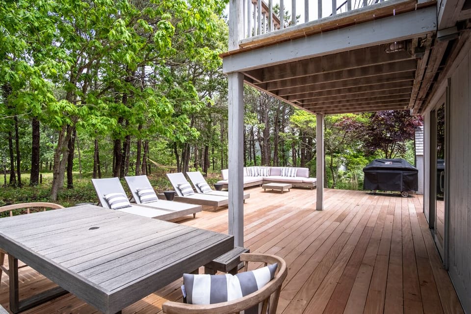 Expansive outdoor deck with glimpse of beach through the pines