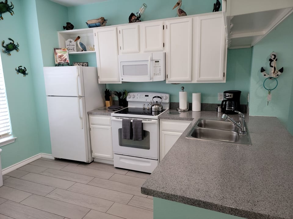 Kitchen is complete with pots, pans, dishes, glasses, & small appliances