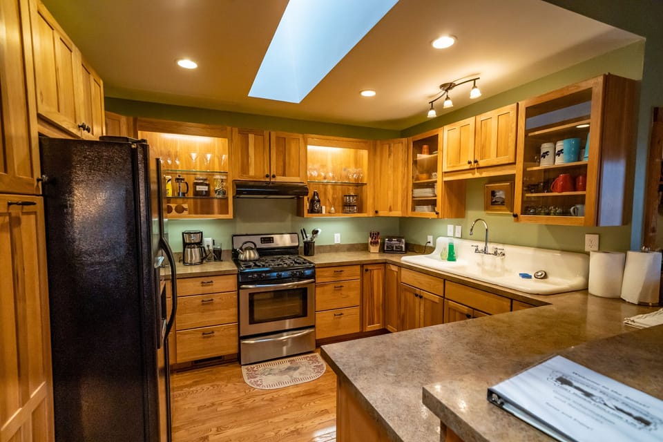 Fully stocked cook's kitchen with gas range and full-size fridge/freezer.