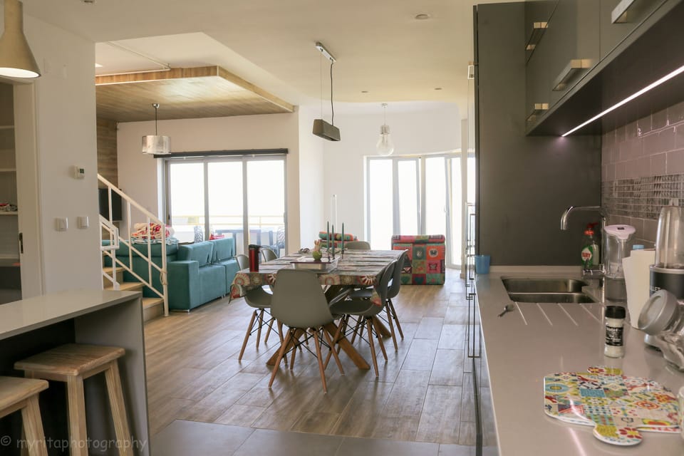 Open plan kitchen, dining and living with picture windows to the ocean & balco