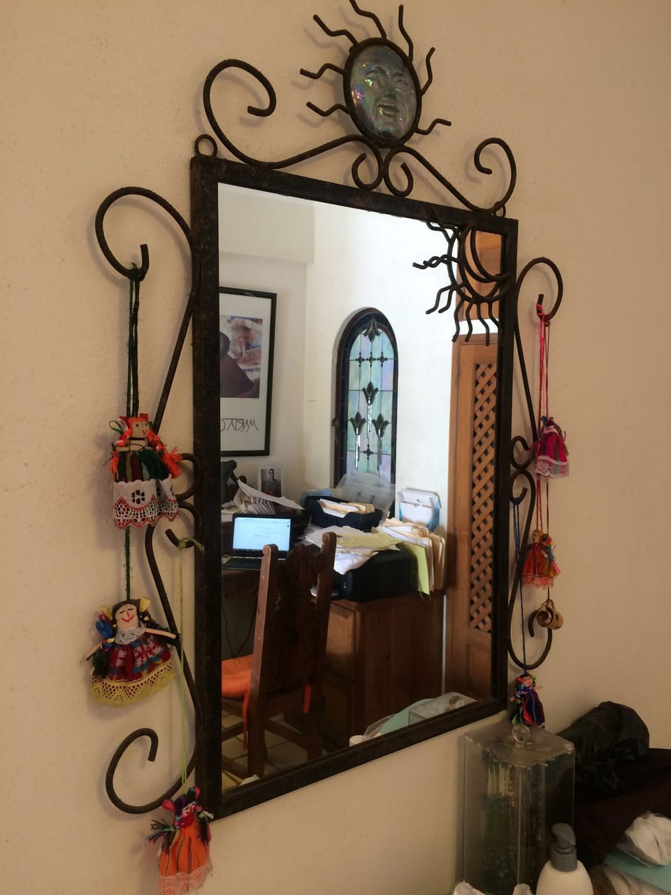 Our bedroom mirror with colorful dolls and reflecting a stained glass window