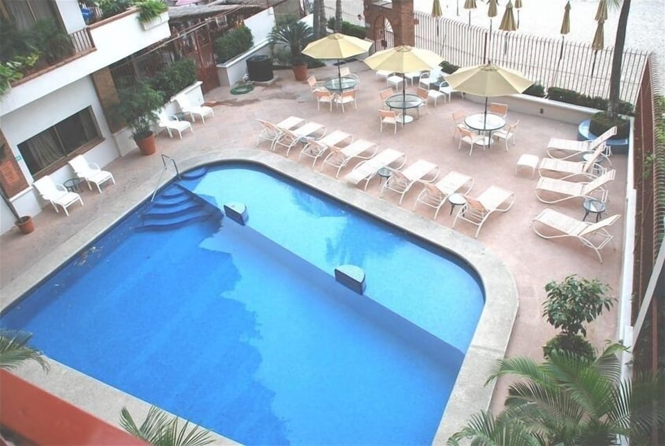 Gated large Pool with Deck with lounges, tables & chairs next to the beach