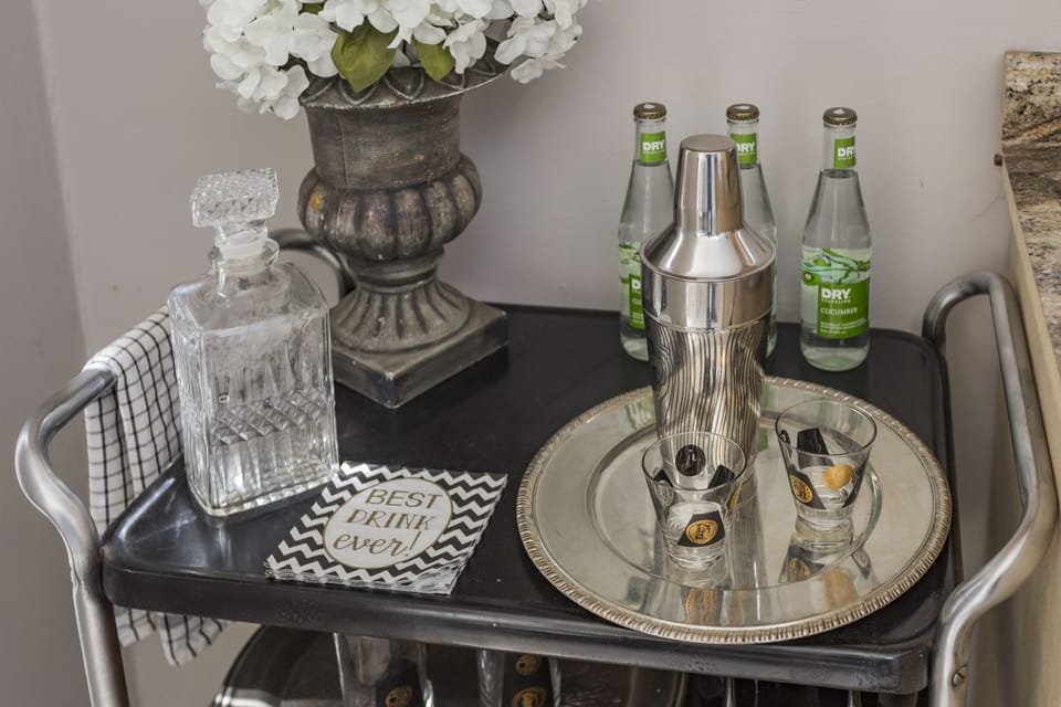 The bar cart is equipped for enjoying an adult beverages.  