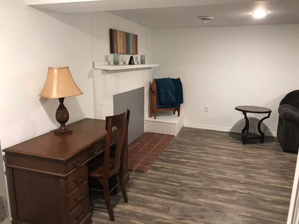 From bottom of stairs to downstairs living area with non-working fireplace.  