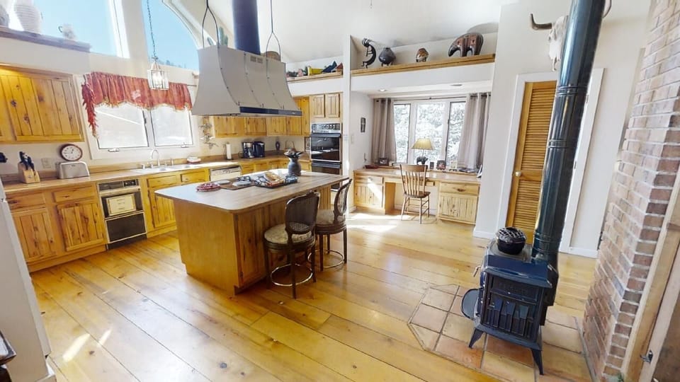 Gather around the spacious island in this sunlit kitchen, where warm wood tones and charming details invite you to cook, share meals, and create memories together in a truly welcoming space.