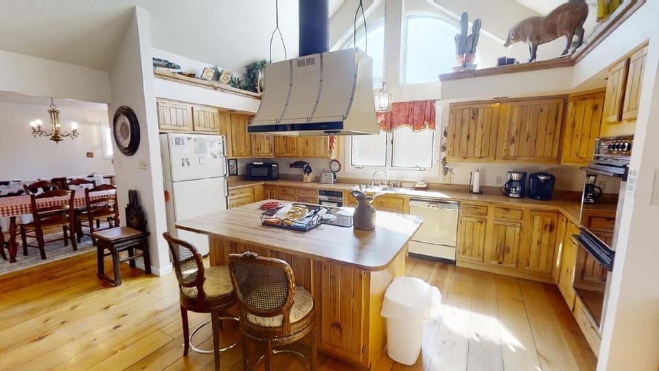 Gather around this spacious kitchen island where your group can prep meals together in a warm, rustic space filled with natural light and charming wood details.