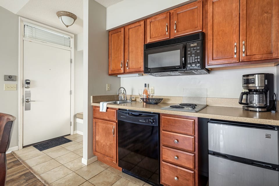 The unit is equipped with a stove, a coffee maker, and a mini fridge for your culinary needs and refreshment.