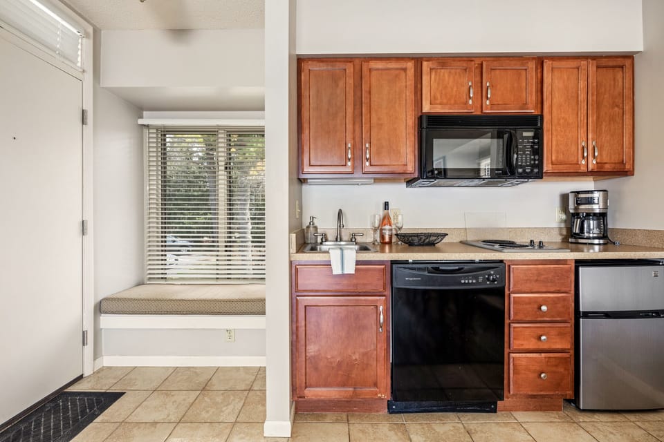 The unit features a cozy window seat along with a fully-equipped kitchen for your comfort and convenience.