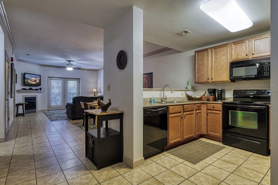 Kitchen, Stainless Sink, Wood Cabinets, Tile Floor, Coffee, Keurig,  Cups, TV.
