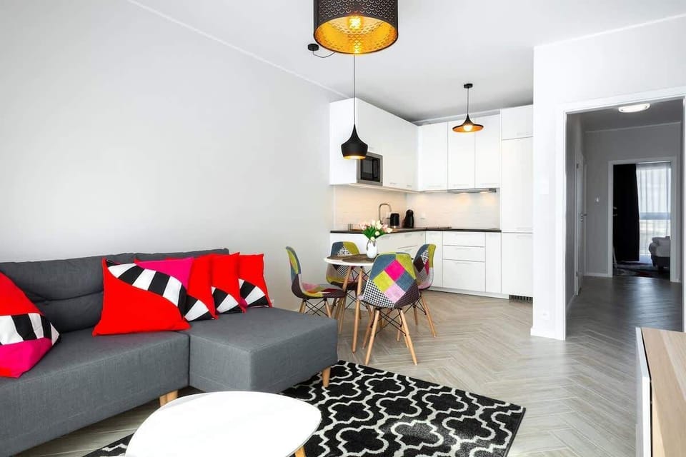 A living room with a grey sofa on which decorative cushions lie. 