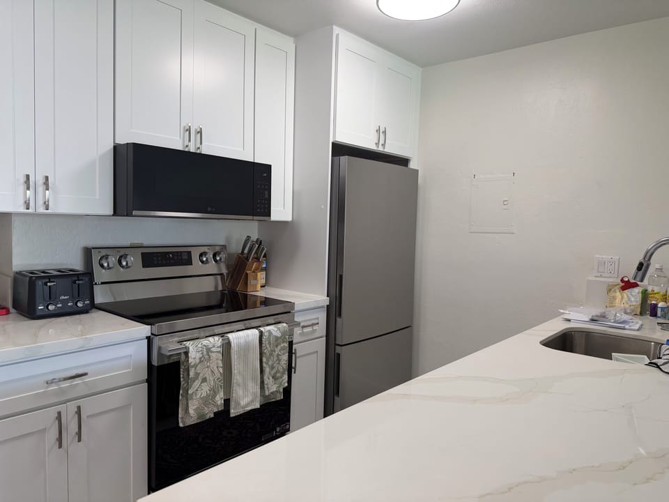 Modern and spacious kitchen with new appliances and quartz countertops.