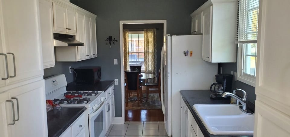 Fully stocked galley kitchen with large farmhouse sink and loads of cupboards. 